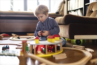 Toddler playing with a wooden railway