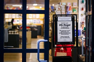 A sign at the entrance of a shop indicates the new retail access restrictions to combat the COVID-19 pandemic in Duesseldorf
