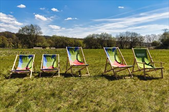 Five deckchairs in a meadow