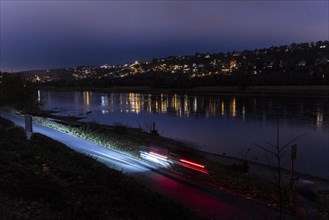 A person rides a bicycle at blue hour along the Elbe cycle path in Dresden