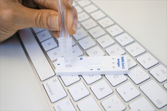 Symbol photo on the subject of ' Compulsory testing in the office'. A Sars Covid-19 antigen rapid test lies on the keyboard of a computer. Berlin