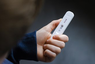 A child holds a positive SARS-CoV-2 Rapid Ag Antigen rapid test. Berlin
