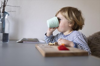 Subject: Toddler drinking from a plastic cup