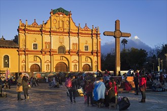 Mexicans at plaza with wooden cross and cathedral of the city San Cristobal de las Casas