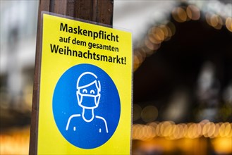 A sign indicating that masks are compulsory stands out at the Christmas market on Alexanderplatz in Berlin