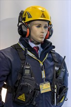 Emergency technician doll with yellow helmet and headphones and on jacket with two radio transmitters