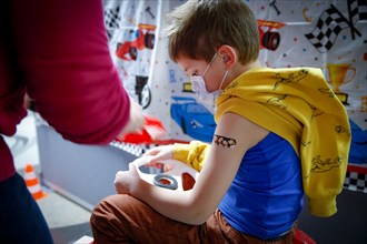 A boy has a patch applied after vaccination with the BioNTech Pfizer childhood vaccine at a COVID-19 vaccination and testing centre at Autohaus Olsen in Iserlohn