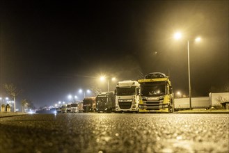 Trucks standing at night in fog at the Freienhufener Eck rest area near Schipkau