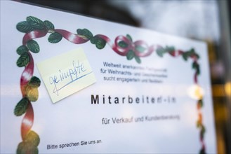 A notice about the search for a vaccinated employee is seen at the Christmas market on Breitscheidplatz in Berlin