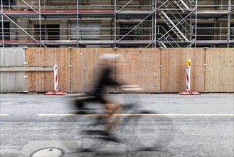 A cyclist stands out in front of a construction site in Berlin