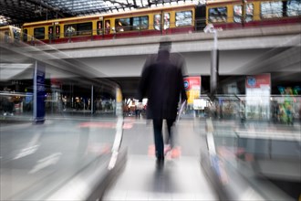 A man exits an escalator in the main station of Berlin