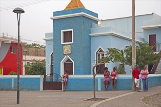 Creole man and women in front of the blue Esparagos church