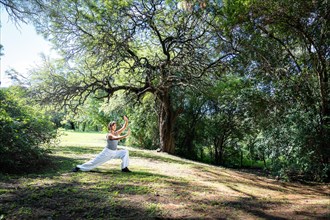 A woman practices Tai Chi in parks. Practicing outdoors provides a calm and relaxing environment for meditation and concentration
