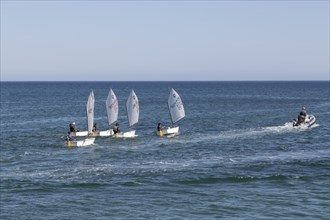 Optimist type dinghies of a sailing school sailing in the Atlantic Ocean off the coast of Lagos