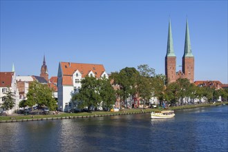 Tourist boat on the river Trave and the Luebeck Cathedral