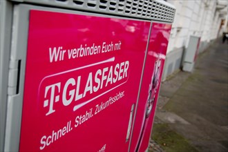 A Deutsche Telekom switch box is covered with a poster advertising fibre optics in Dortmund