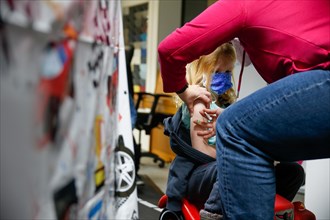 A girl is vaccinated by a doctor with the BioNTech Pfizer children's vaccine in a COVID-19 vaccination and testing centre at the Olsen car dealership in Iserlohn