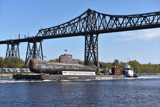 Tugs pulling submarine U 17 on a pontoon in the Kiel Canal under the Rendsburg High Bridge