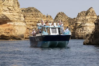 Tourists on a pleasure boat on the rocky coast of Lagos