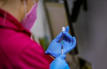 An employee draws up syringes of BioNTech Pfizer vaccine at a COVID-19 vaccination and testing centre at Autohaus Olsen in Iserlohn