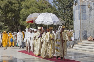 Orthodox priests with parasols during ceremony walking around the Church of Our Lady Mary of Zion