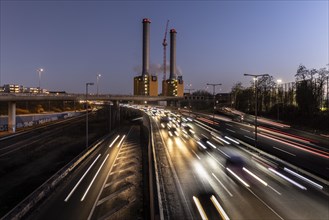 Congested traffic on the A100 with a view of the Wilmersdorf combined heat and power plant looms at blue hour in Berlin