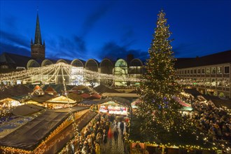 Huge decorated Christmas tree during Xmas fair on the market place in front of town hall in Luebeck