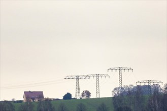 Electricity pylons loom next to a residential house in Kunnerwitz