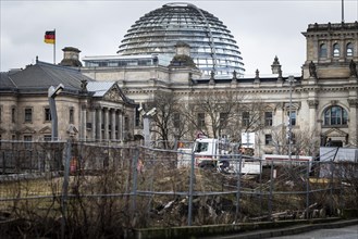 The German Bundestag looms behind an area cordoned off with construction fences in Berlin