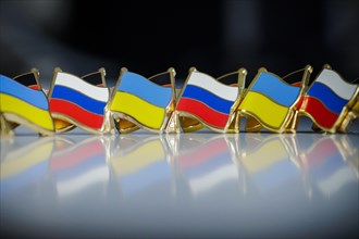 Symbolic photo on the topic ' Diplomacy between Russia and Ukraine '. Pins with the national flags of Russia and Ukraine stand on a table. Berlin