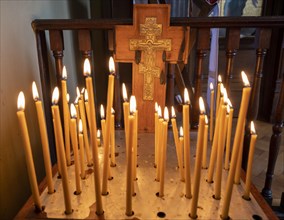 Burning candles in front of a cross in the Russian Chapel