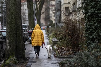 A woman with a dog walking in the rain in Berlin