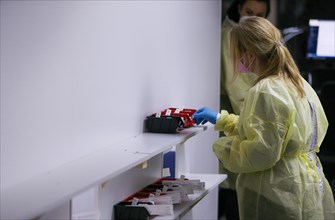A staff member checks rapid tests at a COVID-19 vaccination and testing centre at Autohaus Olsen in Iserlohn