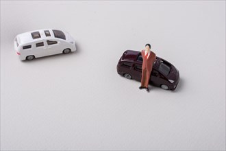 Tiny figurine of man miniature before a car