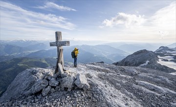 Mountaineer at a secondary peak of the Hochkoenig with summit cross