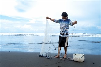 Fisherman with his net in the Pacific Sea. Seascape