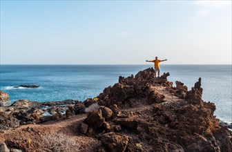 Tourist with open arms on a volcanic trail on the beach of Tacoron on El Hierro