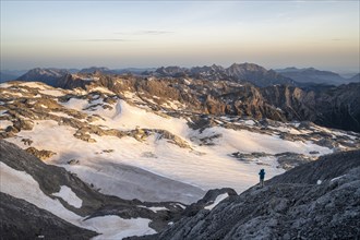 View of rocky plateau with snow and glacier at sunrise