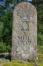 Old Swedish milestone from 1707 by the wayside in a grove in front of Laeckoe Castle by Lake Vaenern