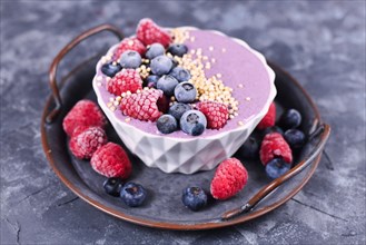 Healthy pink yogurt and fruit smoothie bowl decorated with raspberry