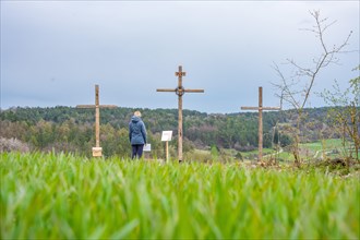 Woman standing in front of wooden crosses on Osterweg