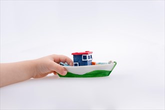 Little colorful model boat in hand on white background