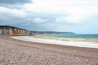 Scenery landscape view of pebble beach and cliffs in background in Dieppe in Seine Maritime department in the Normandy region of northern France