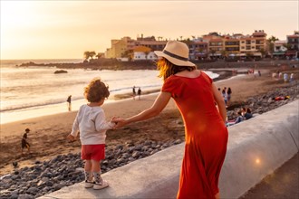 Mother and son at sunset on vacation on the beach of Valle Gran Rey village on La Gomera