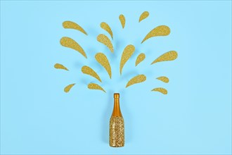 Golden splashing Champagne bottle on blue background