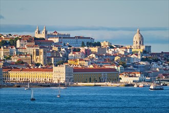 View of Lisbon Alfama district with National Pantheon and Monastery of St. Vincent over Tagus river from Almada with yachts tourist boats on sunset. Lisbon