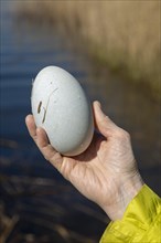 Woman holding large plaster egg