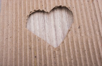 Heart shaped cut out of a brown cardboard