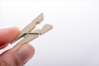 Hand holding a small wooden clothespin in hand