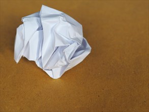 Crumpled paper over brown background with copy space